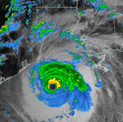 Satellite image of a hurricane near a coastline with intense eye and spiral bands.